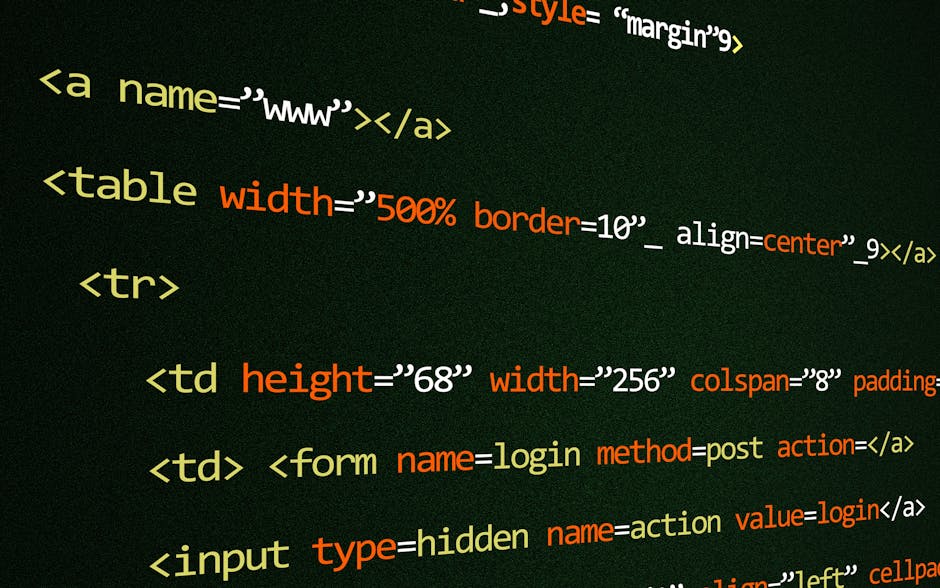 A photograph captures a close-up view of a computer screen displaying lines of HTML code in various colours such as beige, red, and white against a dark background. The code includes tags like <table>